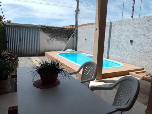 a white table and chairs with a swimming pool at Casa Praia Ilha da Croa/Carro quebrado in Barra de Santo Antônio