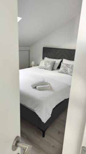 Un dormitorio con una cama grande con sábanas y almohadas blancas. en Apartman Polaris Posušje, en Posušje