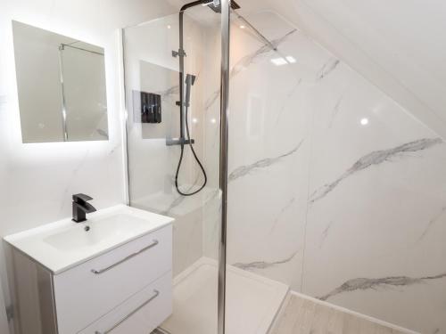 a white bathroom with a shower and a sink at Maritos in Holywell