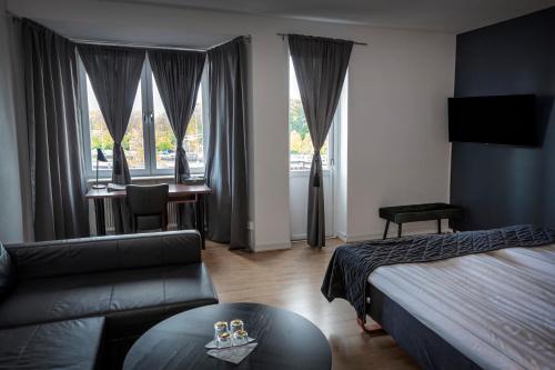 une chambre d'hôtel avec un lit et un canapé dans l'établissement Hotell Skövde, à Skövde