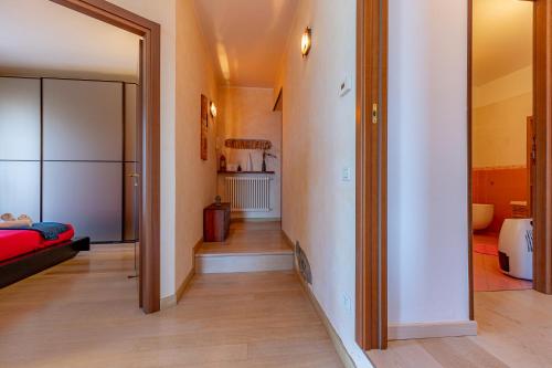 un corridoio che conduce a un soggiorno con letto rosso di [Como-Blevio] Suite lake view + private garage a Blevio
