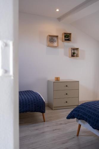 une chambre avec un lit et une commode dans l'établissement Gîte de la Place classé 3 étoiles Centre Bourg CAUTION OBLIGATOIRE, à Les Bordes