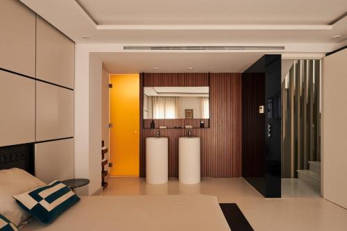 een woonkamer met gele muren en een kamer met een bed bij San Nicolas Luxury Home with prívate terrace in Córdoba