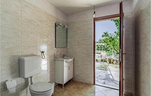 a bathroom with a toilet and a sink and a mirror at Awesome Home In Viganj With Kitchen in Viganj