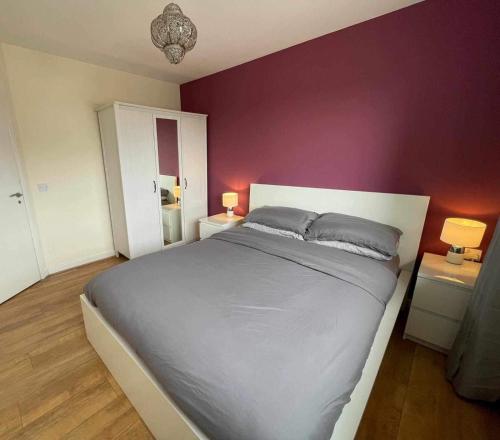 a bedroom with a large bed with purple walls at One bedroom with Great city views in London