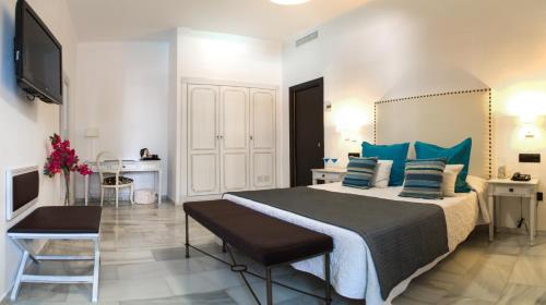 1 dormitorio con 1 cama grande con almohadas azules en Hotel La Fonda, en Benalmádena