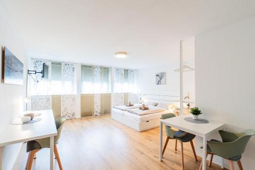 een witte kamer met een wastafel, een tafel en stoelen bij Modern und Renoviert in Neurenberg