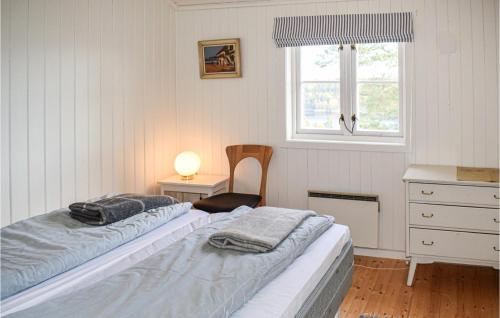 a bedroom with two beds and a desk and a window at Beautiful Home In ros With Kitchen in Fagerstrand