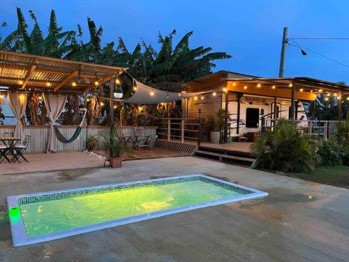 una piscina en un patio con una casa en El Camper RV with pool. en Aguadilla
