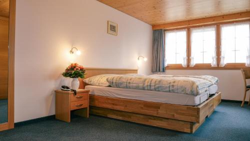 ein Schlafzimmer mit einem Bett in einem Zimmer mit Fenstern in der Unterkunft Hotel und Gasthaus Bad Gonten in Gonten