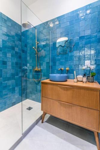 une salle de bain carrelée bleue avec un lavabo et une douche dans l'établissement Luxury flat Champs Élysées Air Cond. 6 Pers, à Paris