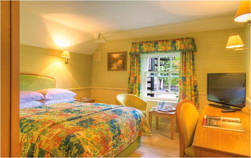 a bedroom with a bed and a tv and a window at York Pavilion Hotel, Sure Hotel Collection by Best Western in York