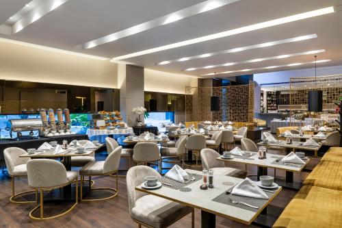 Hotel 93 Luxury Suites by Preferred في بوغوتا: مطعم فيه طاولات وكراسي في الغرفة
