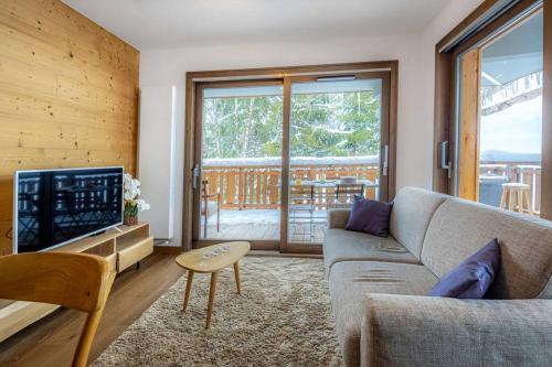 un salon avec un canapé et une télévision dans l'établissement Les Freinets - Apt D303 - BO Immobilier, à Châtel