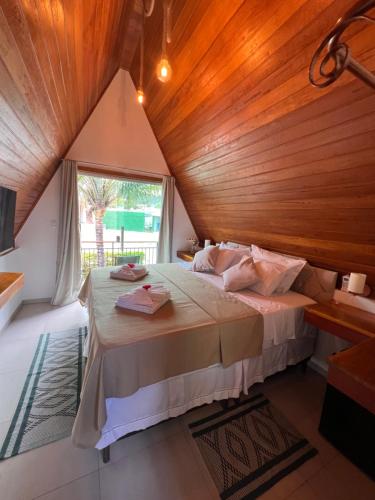 穆庫熱的住宿－Pousada Primavera，一间卧室设有一张带木制天花板的大床