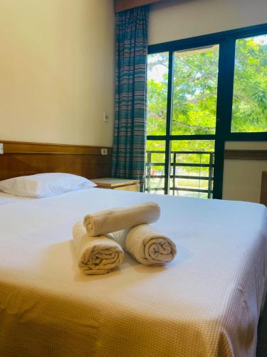 1 cama con 2 toallas y ventana en Canto da Ilha, en Florianópolis
