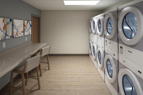 a laundry room with a row of washing machines at Candlewood Suites Murfreesboro by IHG in Murfreesboro