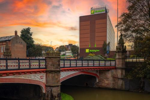a bridge over a river with a building in the background at Holiday Inn Leicester City by IHG in Leicester