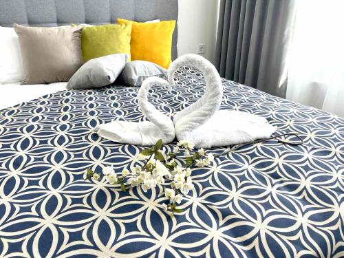Dos toallas de cisne en una cama con flores. en Люкс апартаменти в затишному ЖК бізнес класу en Kiev