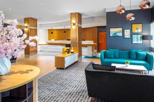 uma sala de estar com um sofá azul e uma mesa em Holiday Inn Leicester City, an IHG Hotel em Leicester