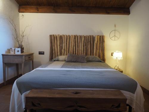 - une chambre avec un grand lit et une tête de lit en bois dans l'établissement Els Noguers Turisme, à Castellar del Riu