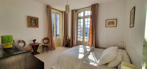 una camera da letto con un letto, una scrivania e finestre di Villa Art Nouveau ad Angoulême