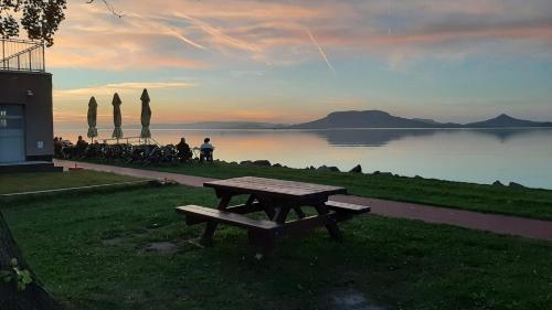 a picnic table sitting next to a body of water at Sunshine Villa Fonyódliget in Fonyód