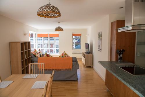 a kitchen and a living room with a couch at Toothbrush Apartments - Central Ipswich St Peters St in Ipswich