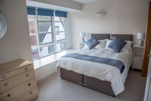 um quarto com uma cama grande e 2 janelas em Toothbrush Apartments - Central Ipswich St Peters St em Ipswich