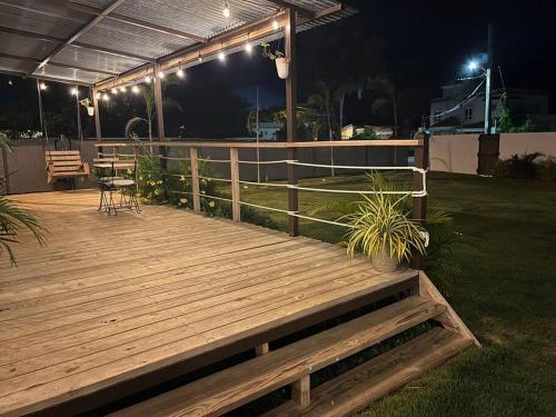 una terraza de madera con mesa y sillas. en El Camper RV with pool. en Aguadilla
