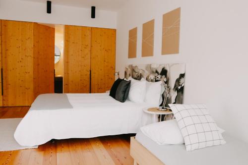 a bedroom with a white bed and a couch at CAMBEIROS - Guest House in Alenquer