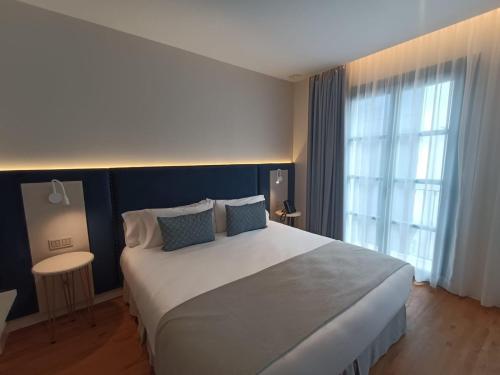 a bedroom with a large bed and a large window at Hotel Boutique La Brisa del Mar in Estepona