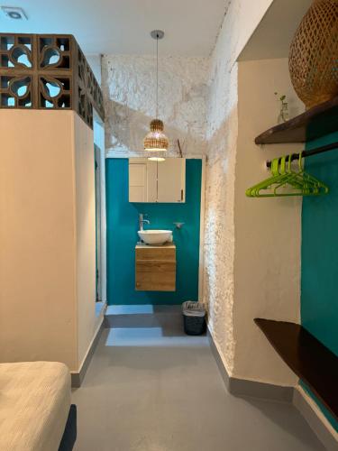 baño con lavabo y pared azul en El Barrio Hostal en Cartagena de Indias