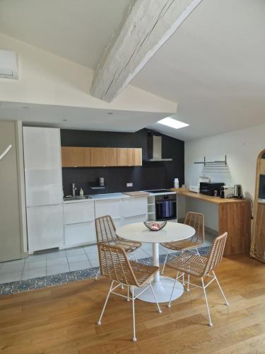 eine Küche mit einem Tisch und Stühlen im Zimmer in der Unterkunft Atipyc Nimes in Nîmes
