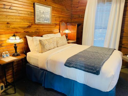 a bedroom with a bed in a room with wooden walls at Dabbs Hotel Bed and Breakfast in Llano