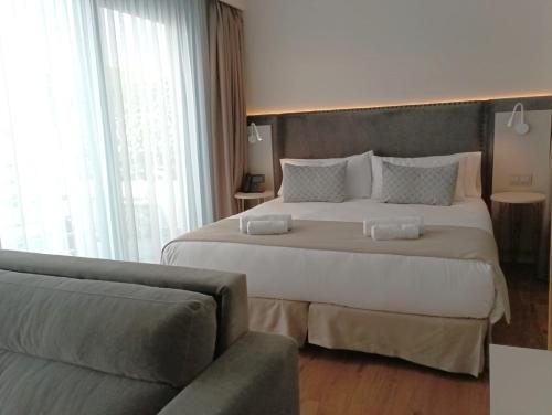 ein Hotelzimmer mit einem großen Bett und einem Sofa in der Unterkunft Hotel Boutique La Brisa del Mar in Estepona