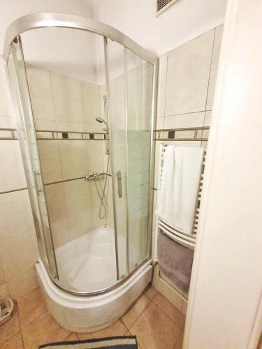 a shower with a glass door in a bathroom at Main Square Rooms in Krakow