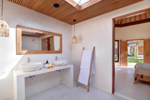 La salle de bains est pourvue d'un lavabo et d'un miroir. dans l'établissement Two Bedroom Villa in Bingin Beach, à Uluwatu