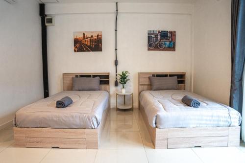 two beds sitting next to each other in a room at Monkey Toe Guesthouse in Chiang Mai