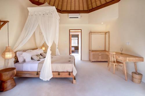 - une chambre avec un lit à baldaquin et un bureau dans l'établissement Two Bedroom Villa in Bingin Beach, à Uluwatu