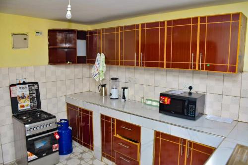 cocina con microondas y encimera en The Green Baroness, en Eldoret