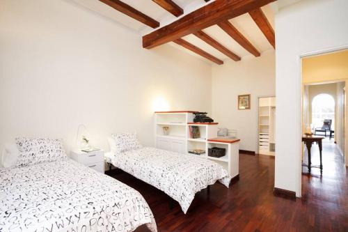 ein weißes Schlafzimmer mit 2 Betten und einem Tisch in der Unterkunft FANTASTIC apartment in Barcelona in Barcelona