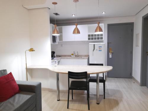 a kitchen with a table and chairs in a room at Flat INCRIVEL na Vila Olimpia in Sao Paulo
