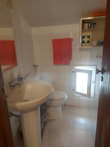 a bathroom with a white toilet and a sink at o Roxo in Castelo de Vide