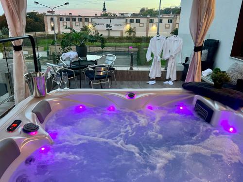 布達佩斯的住宿－Boutique Hotel & Event Center，客房内的按摩浴缸配有紫色灯