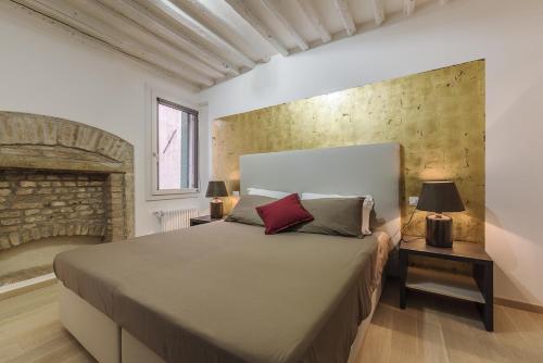 a bedroom with a large bed and a brick wall at Cà Del Tentor in Venice