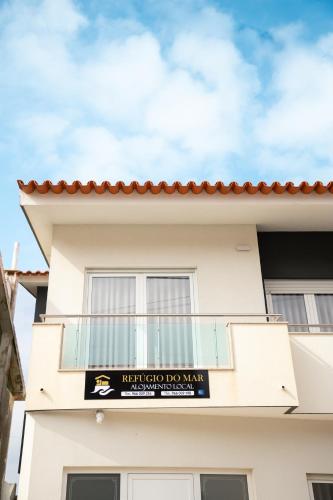 a white building with a sign on it at Refúgio do Mar in Aguçadoura