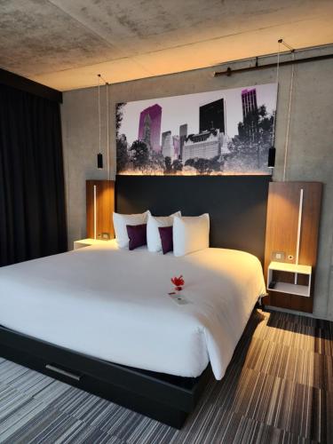 a bedroom with a large white bed with a flower on it at Grand Hotel Times Levis in Lévis