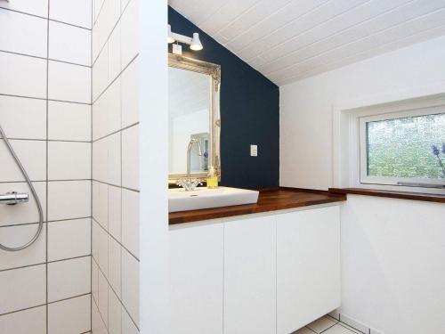 a bathroom with a sink and a mirror at 6 person holiday home in Fårvang in Fårvang