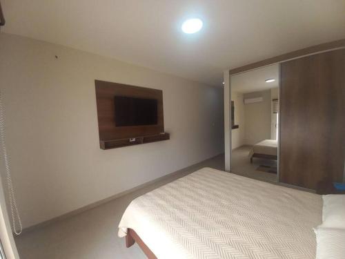 um quarto com uma cama e uma televisão na parede em Elegante departamento en Equipetrol em Santa Cruz de la Sierra